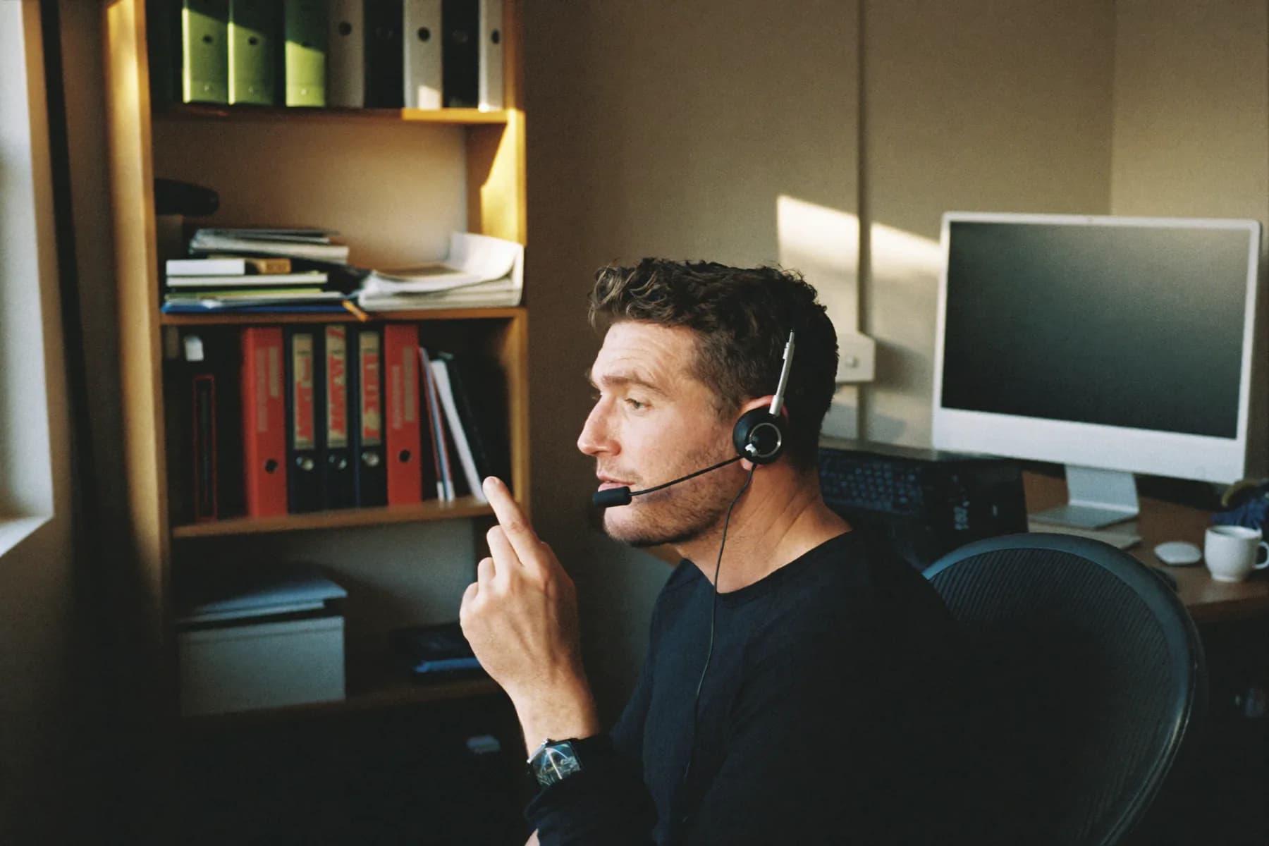 Kollege mit Headset an seinem Arbeitsplatz zu Hause
